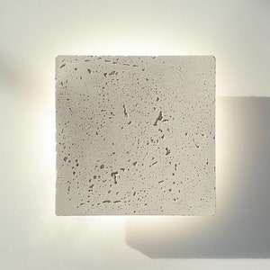 Puede incluir: Un juego de tres tazas de cerámica con un acabado mate moteado. Las tazas son de color crema, gris claro y gris oscuro. Cada taza tiene un diseño simple y minimalista y un asa redondeada.