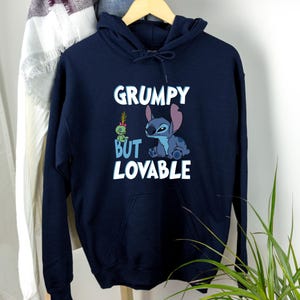 May include: A navy blue hoodie with a Stitch character and the text "Grumpy But Lovable" printed on the front.