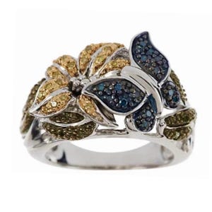 May include: A silver ring with a butterfly and flower design. The butterfly is made of blue diamonds and the flower is made of yellow and green diamonds.
