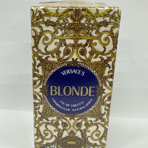 May include: A rectangular perfume box with a gold and white baroque pattern. The box features a blue circle with the text "VERSACE'S BLONDE EAU DE TOILETTE NATURAL SPRAY". The box contains 30 ml / 1 fl oz.