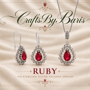 May include: A jewellery set featuring two teardrop-shaped earrings and a matching pendant necklace, each with a central red ruby stone surrounded by intricate silver filigree. The text reads CraftsByBaris, RUBY, and 925 STERLING SILVER FILIGREE JEWELLERY.