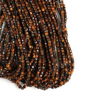 May include: A strand of brown and gold tiger's eye beads, each bead is a square shape.