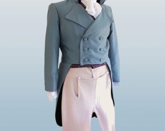 Puede incluir: Un frac de color verde azulado con doble botonadura y pantalón a juego. El abrigo tiene un cuello alto y seis botones. El pantalón es de color beige claro con cintura alta y bragueta abotonada. Se ve un corbatín blanco en el cuello.