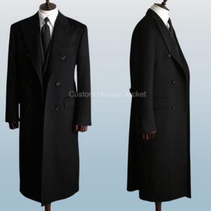 May include: A black overcoat on a mannequin. The double-breasted coat has a notched lapel, a matching vest, and a white dress shirt and black tie. The floor-length coat has a classic, tailored design. The text "Custom Hussar Jacket" is visible.