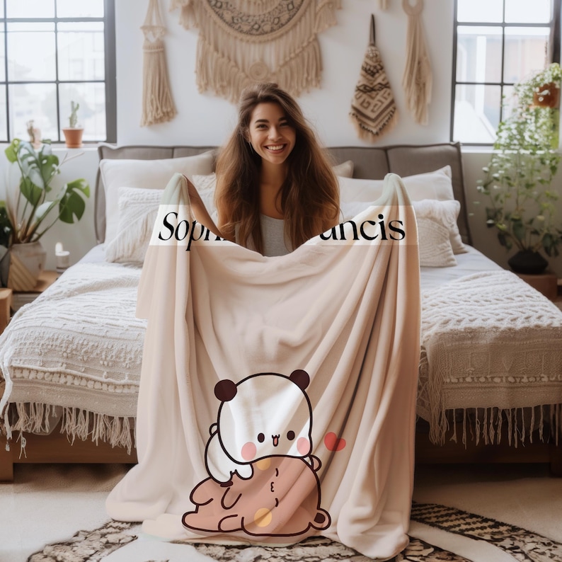 May include: A soft, beige fleece blanket with a cute cartoon panda and bear design. The blanket has the names "Sophia" and "Francis" printed on it.