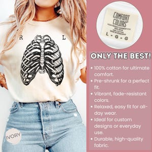May include: Ivory-colored t-shirt featuring a black and white rib cage graphic. The shirt has the text "R" and "L" on either side of the graphic. The tag reads "COMFORT COLORS" and "ONLY THE BEST!" is printed on the side.