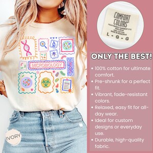 May include: Ivory-colored t-shirt featuring a colorful microbiology-themed design with various scientific illustrations and the word "MICROBIOLOGY". The shirt includes a Comfort Colors label and the text "ONLY THE BEST!"