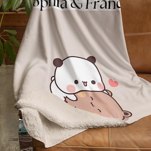 May include: A beige fleece blanket with a panda and bear illustration. The blanket has the text "Sophia & Franc" printed on it.