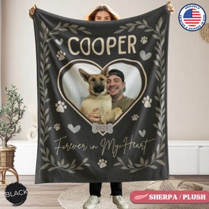 Puede incluir: Manta negra de sherpa/felpa con una foto en forma de corazón de una persona y un perro, con el nombre "COOPER" arriba. La manta incluye huellas de patas, corazones y el texto "Forever in My Heart" y "2025".
