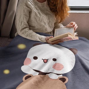 Pu&ograve; includere: Una morbida coperta in peluche con un simpatico panda dei cartoni animati che cavalca un orso marrone. La coperta &egrave; blu scuro con stelle gialle.