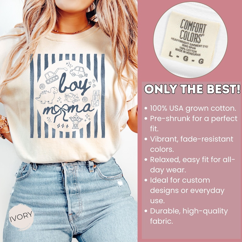 May include: Ivory-colored t-shirt with a blue and white design featuring the words "boy momma" and illustrations of toys. The shirt is made of 100% USA grown cotton.