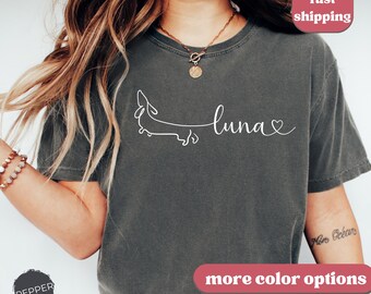 Może przedstawiać: Szary t-shirt z białym konturem jamnika i napisem "luna" z sercem.