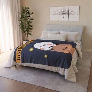 Pu&ograve; includere: Una coperta in pile blu navy con il nome personalizzato "Justin" in testo giallo. La coperta presenta un panda e un orso dei cartoni animati che si abbracciano su uno sfondo di notte stellata.
