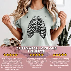 May include: A light green t-shirt featuring a black and white anatomical rib cage design. The letters "R" and "L" are printed above the rib cage. The text "CUSTOMERS LOVE OUR T-SHIRTS!" is printed below the design.