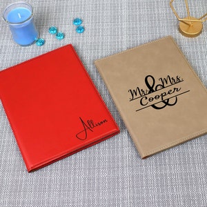 以下が含まれることがあります： 「Allison」という名前が書かれた赤い革製のジャーナルと、「Mr. & Mrs. Cooper」とアンパサンド記号が書かれた茶色の革製のジャーナルの2冊のパーソナライズされた革製のジャーナルです。