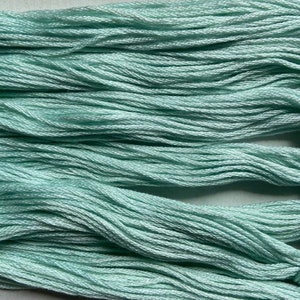 May include: A bundle of light blue embroidery floss, with multiple strands of thread bundled together.