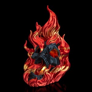 Könnte beinhalten: Ein schwarzer Schädel mit einem roten und goldenen Flammenmuster. Der Schädel ist hohl und scheint ein Kerzenhalter zu sein.