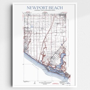 May include: A framed map of Newport Beach, California, from the USGS. The map is detailed with blue and brown watercolor accents, showing the coastline, roads, and geographical features. The title "NEWPORT BEACH" is printed in blue at the top.