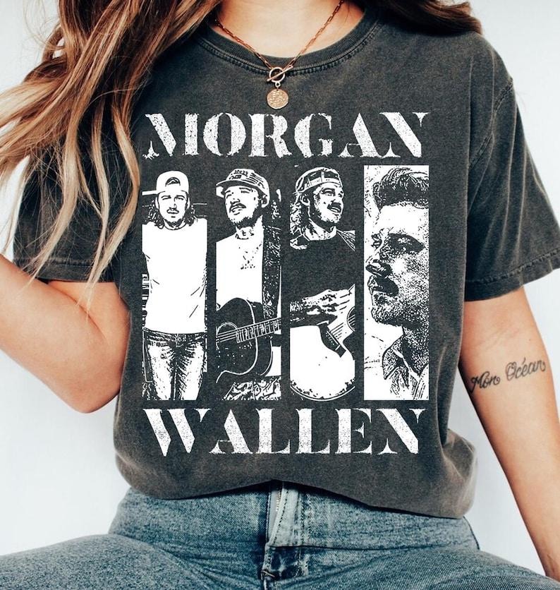 May include: Dark gray t-shirt featuring the name "MORGAN WALLEN" in large white block letters. The shirt displays four black and white images of a man in different poses. The shirt is made of a soft material.