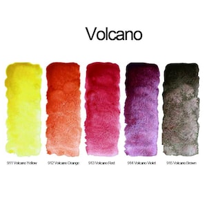 Może przedstawiać: Zestaw pięciu prostokątnych pr&oacute;bek akwareli z etykietą Volcano, zawierający kolory 911 Volcano Yellow, 912 Volcano Orange, 913 Volcano Red, 914 Volcano Violet oraz 915 Volcano Brown. Każda pr&oacute;bka prezentuje teksturowaną aplikację farby na papierze.