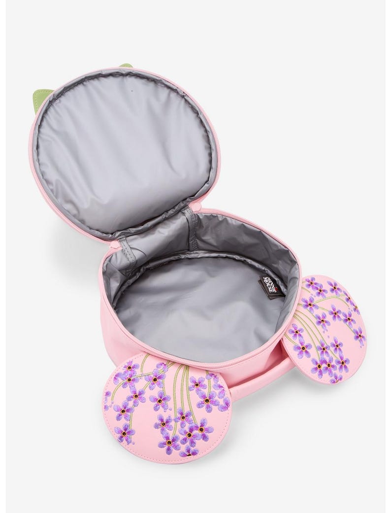 May include: Pink lunch bag with a green handle and two round side pockets. The side pockets and the bag's front feature a purple floral design. The interior is gray and insulated. The bag is open, revealing the inside.