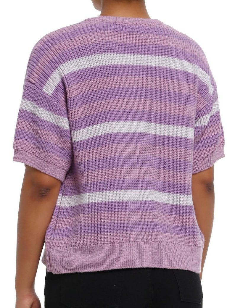 May include: A short-sleeved sweater in shades of purple and white. The sweater features horizontal stripes in varying widths. The ribbed knit fabric has a soft texture. The garment is a casual top.