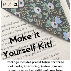 以下が含まれることがあります： 「Make it Yourself Kit!」の文字が入った、花柄の生地のブックマークキット。ブックマークは、青とピンクの花が咲く濃い色の背景が特徴です。キットには、裁断済みの生地、接着芯、説明書、型紙が含まれています。