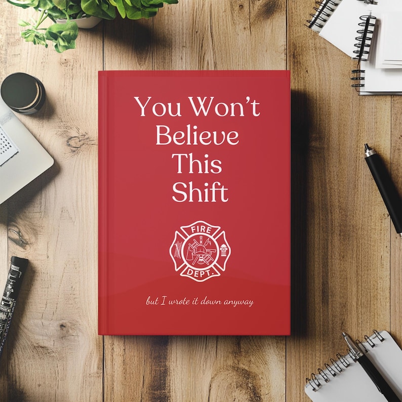 May include: A red notebook with the text "You Won't Believe This Shift" and a fire department emblem. The phrase "but I wrote it down anyway" is printed at the bottom. The notebook is on a wooden surface.