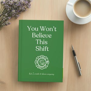 May include: A green notebook with the text "You Won't Believe This Shift" and a fire department emblem. The notebook is on a wooden surface, next to a cup of coffee and a pen.