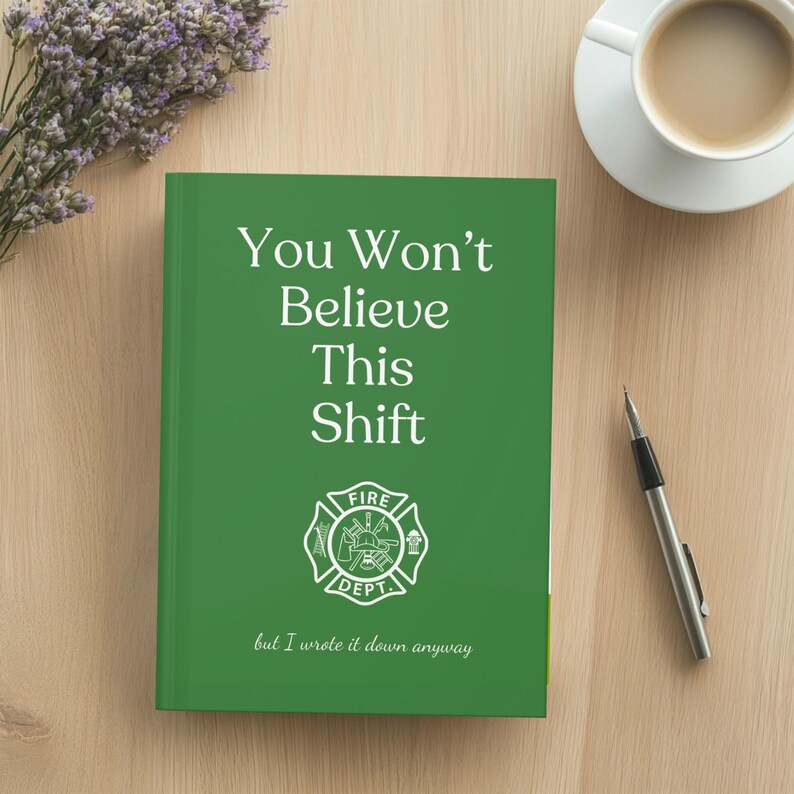 May include: A green notebook with the text "You Won't Believe This Shift" and a fire department emblem. The notebook is on a wooden surface, next to a cup of coffee and a pen.