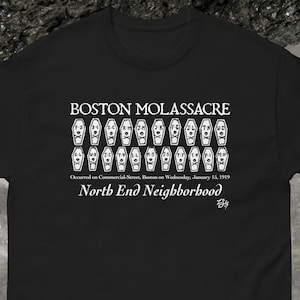 May include: Black t-shirt with a white graphic of coffins with faces and the text "BOSTON MOLASSACRE", "Occurred on Commercial Street, Boston on Wednesday, January 15, 1919", and "North End Neighborhood".
