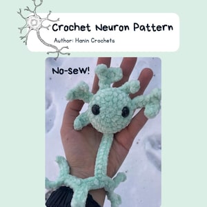 Könnte beinhalten: Ein gehäkeltes Neuron-Muster in Hellgrün, gehalten in einer Hand vor einem schneebedeckten Hintergrund. Das Neuron hat einen abgerundeten Körper mit mehreren Ranken und schwarzen Knopfaugen. Text lautet "Crochet Neuron Pattern" und "No-sew!"