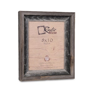 May include: A rustic wood picture frame with a grey wash finish. The frame is 8x10 inches and is made from 100% recycled materials. It is made in the USA and says "Rustic Decor" on the front.