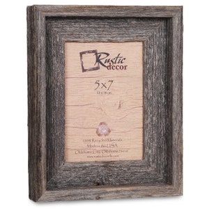 May include: A rustic wood picture frame with a dark gray finish. The frame is 5x7 inches and is made from 100% recycled materials. The frame is made in the USA. The frame has a simple design with a beveled edge.