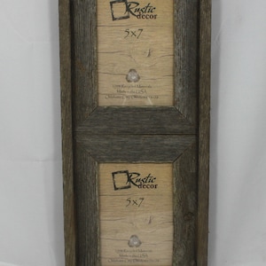 May include: A rustic wood picture frame with two 5x7 inch openings. The frame is made from reclaimed wood and has a distressed grey finish. The frame is made in the USA and is 100% recycled materials. The text "Rustic decor" is printed on the frame.