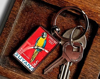 Macaw Keyring, red - upcycled 1967 postage stamp from Guyana