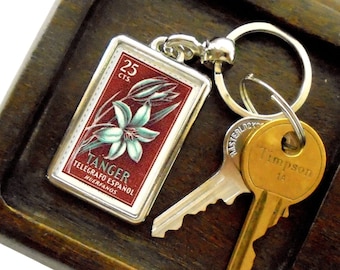 Lily Keyring, brown background - upcycled 1957 Tangier charity stamp