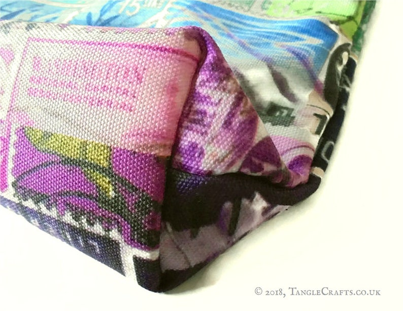 May include: Close-up of a colourful tote bag with a purple, black and white design. The bag is made of canvas and has a  "TangleCrafts.co.uk" label.