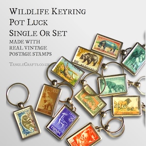 May include: A set of vintage postage stamp keychains featuring various wildlife animals, including a hippopotamus, bear, crocodile, elephant, deer, lion, and more. The keychains are made with real vintage postage stamps and are available as a single keychain or a set.
