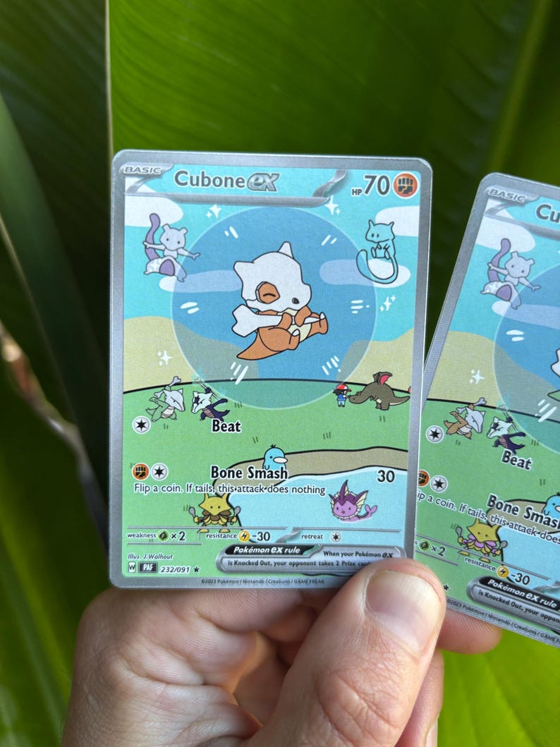 Op de afbeelding: Twee Cubone EX Pok&eacute;mon-ruilkaarten. De kaarten tonen een Cubone-personage met een bottenhelm en een lichtblauwe achtergrond. De kaarten hebben tekst als "Bone Smash" en "Beat".