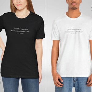 May include: Two t-shirts, one black and one white, with the text 'I yield for a question while retaining the floor cory booker' printed on the front.
