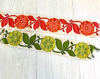 May include: Two pieces of vintage floral trim with a white background. One trim features red and orange flowers with green leaves. The other trim features green and yellow flowers with green leaves.