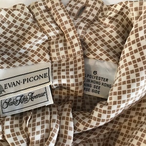 May include: A white and brown checkered blouse with a brown collar and a label that reads "Evan-Picone Saks Fifth Avenue" and "6 Polyester Made in Hong Kong Hing See Reverse Side".