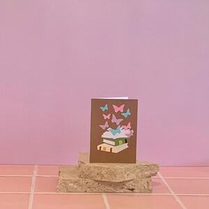Card. Pile Of Books With Butterflies Flying Out Of The Pages. Blank