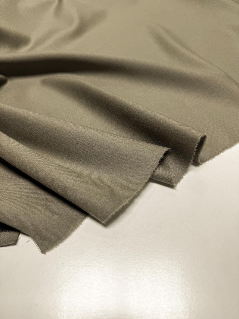 Discover a high-quality Merino Wool in sage color (olive) with a touch of Cashmere thread. This Fabric is ideal for suits, trousers. Merino Wool is a luxurious fabric, made with cashmere fibers, extremely soft and comfortable to wear. This fabric lends a sophisticated look and style to the items made from it.