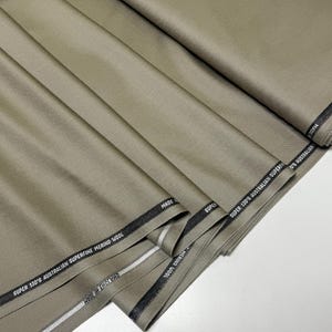 Discover a high-quality Merino Wool in sage color (olive) with a touch of Cashmere thread. This Fabric is ideal for suits, trousers. Merino Wool is a luxurious fabric, made with cashmere fibers, extremely soft and comfortable to wear. This fabric lends a sophisticated look and style to the items made from it.