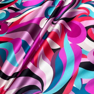 Könnte beinhalten: Nahaufnahme eines lebendigen Stoffes mit einem wirbelnden Muster. Der Stoff weist eine Mischung aus Farben auf, darunter Rosa, Lila, Türkis, Rot, Schwarz und Weiß. Der Stoff hat eine glänzende, satinartige Oberfläche mit sichtbaren Falten.