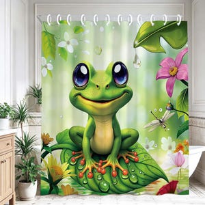 May include: A shower curtain featuring a large green frog with oversized dark eyes sitting on a broad leaf. The design includes vibrant pink and white flowers, green foliage, and a dragonfly against a soft, light green background.