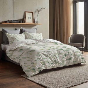 May include: A bed with a white duvet cover and pillowcases featuring a green leaf pattern. The bed is made up with gray pillows and a gray bed skirt. A wooden shelf with books and decor is above the bed.