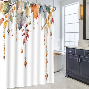 May include: A white shower curtain featuring a watercolour print of hanging autumn leaves in shades of orange, yellow, red, and blue, interspersed with vertical strings of small, round, multi-coloured beads suspended from the branches.